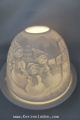 Schneemänner Dome-Light besteht aus einer Porzellankuppel und einem Teller aus Porzellan. In die Kuppel ist ein reliefartiges Design eingearbeitet. Auf dem Teller wird ein Teelicht entzündet und die Kuppel darüber gestülpt